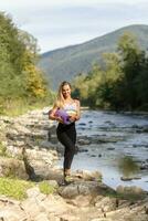 Young woman with slim healthy body standing with yoga mat photo