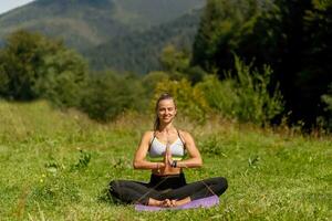 Fitness woman sitting in a yoga pose in a park. photo