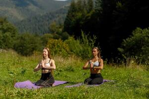 Fitness women in triangle pose while practising yoga at a park. photo