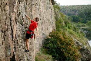 un niña sube un roca. mujer comprometido en extremo deporte. foto