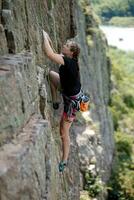 un niña sube un roca. mujer comprometido en extremo deporte. foto