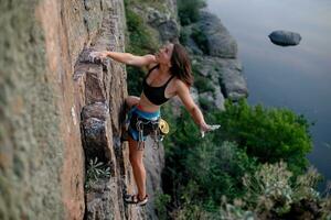 un niña sube un roca. mujer comprometido en extremo deporte. foto