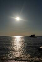 puesta de sol playa en capa mayo nuevo jersey dónde usted lata obtener un genial ver de el Dom yendo abajo a través de el Oceano y el bahía. el reflexión de el Dom en el agua con el hundido Embarcacion mira entonces hermosa. foto