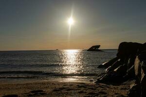 Sunset beach in Cape May New Jersey where you can get a great view of the sun going down across the ocean and the bay. The reflection of the sun on the water with the sunken ship looks so beautiful. photo