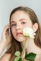 pequeño bonito niña en rosado sostiene el ramo de flores de rosas. foto