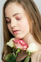 Little pretty girl in pink holds the bouquet of roses. photo