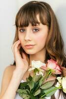 Little pretty girl in pink holds the bouquet of roses. photo