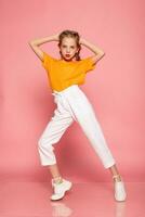 dancing full length little girl on pink studio background photo