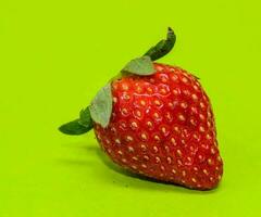 a strawberry on a green background photo