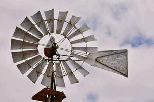 a windmill with a metal pole and a metal roof photo