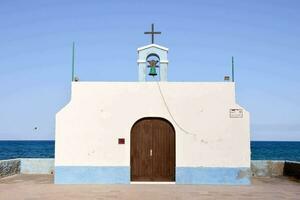 a small white church with a bell on top of it photo