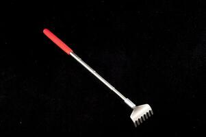 a red and white rake on a black surface photo