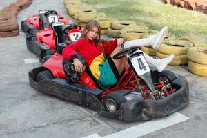 contento morena mujer ganando el karting carrera. foto