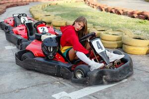 contento morena mujer ganando el karting carrera. foto