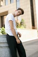 Handsome young hipster stylish man in white shirt, black pants photo