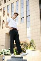 Handsome young hipster stylish man in white shirt, black pants photo