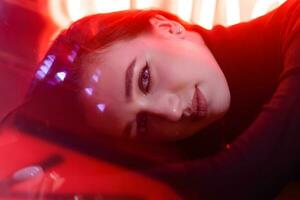 Portrait of a girl on the background of a neon sign of a shop window photo