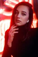 Portrait of a girl on the background of a neon sign of a shop window photo