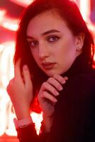 Portrait of a girl on the background of a neon sign of a shop window photo