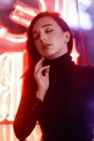 Portrait of a girl on the background of a neon sign of a shop window photo