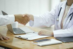 Portrait Of Doctor Shaking Hand Of Patient photo