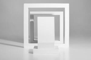 Minimalist podium design of square platforms and frames on gray background photo