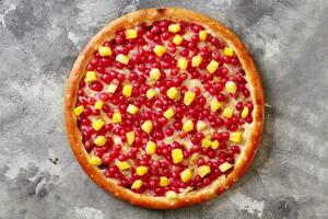 dulce Pizza con rojo grosellas, piña en Derretido queso Mozzarella con condensado Leche en gris superficie foto