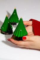 Female hands holding Christmas tree shaped dessert photo