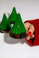 Female hand holding out Christmas tree shaped pastry photo
