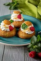 Choux pastries with burnt Swiss meringue, raspberries and mint photo