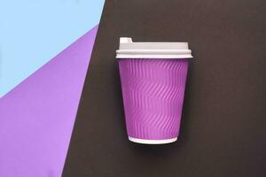 A disposable cardboard coffee cup on colorful background photo