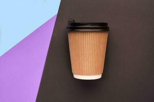 A disposable cardboard coffee cup on colorful background photo