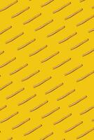Heap of french fries on yellow background, top view photo