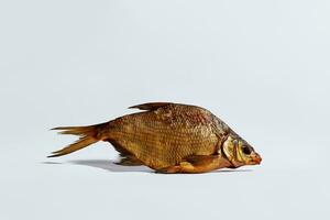 Whole golden cold-smoked bream lying on white background. Traditionally preserved fish. Popular appetizer photo