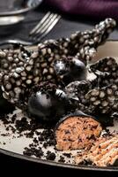 aperitivo con salmón coronilla, tinta calamar, galletas servido en blanco bandeja terminado negro de madera antecedentes. de cerca foto