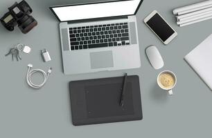 Minimal work space  Laptop, camera, coffee, camera, pen, pencil, notebook, smartphone, stationery on gray background for copy space. photo