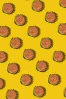 Many tasty fresh unhealthy hamburgers with ketchup and vegetables on yellow vibrant bright background. Top View with Copy Space. photo