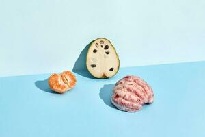 Half of sugar-apple, fruit of Annona squamosa cherimoya and mandarin and grapefruit photo