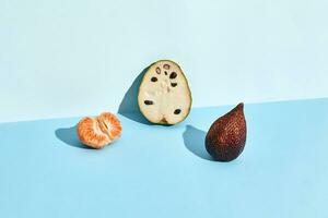 Half of sugar-apple, fruit of Annona squamosa cherimoya and figs and mandarin photo