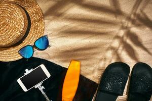 Summer background with straw hat, sunglasses, sunscreen bottle and flip flops photo