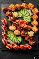 Top view of rolls set, nigiri sushi and gunkan maki with salmon on black slate board photo