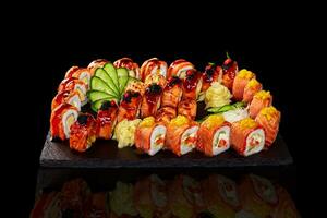 Set of rolls, nigiri sushi and gunkan maki with salmon on black background photo