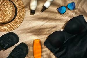 Summer background with straw hat, sunglasses, sunscreen bottle and flip flops photo