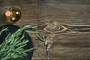 Branches of rosemary on gray wooden table. Rosemary on cutting board. Rustic style, fresh organic herbs. photo