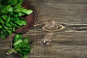Spinach baby leaves on wooden background. Top view. Copy space photo