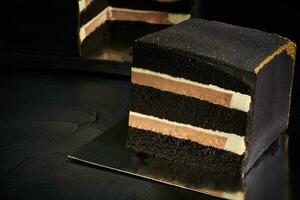 Black square cake with gold edges. Dark background. The view from the top. photo