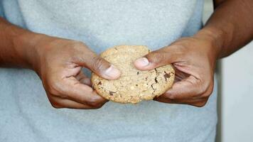 Men's fingers hold a cookie and then break it in half video