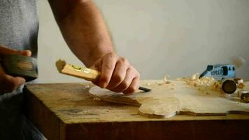 luthier trabajando en el parte superior de un encorvado instrumento con un cincel video