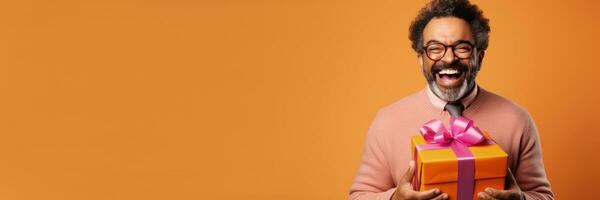 Man expressing joy while unwrapping festive gift isolated on a gradient background photo