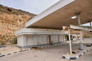 a gas station with a large rock wall behind it photo